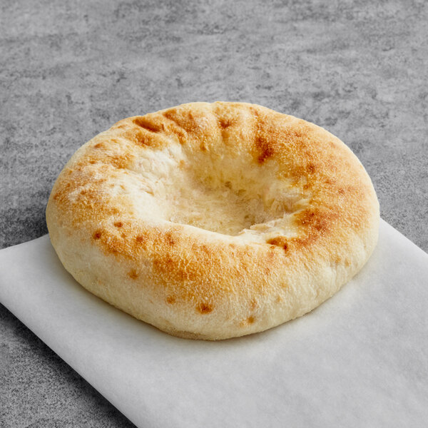 A Just Bagels frozen bialy on a white paper.