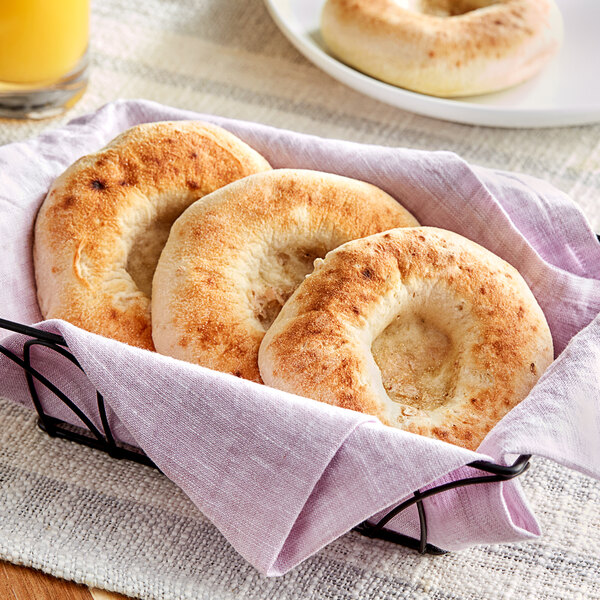 A basket of Just Bagels authentic New York bialys with a hole in the middle.