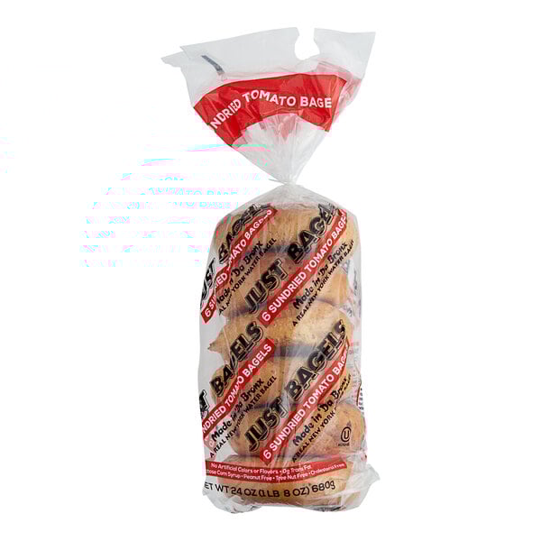 A package of Just Bagels Sundried Tomato Bagels with a plastic bag on top.