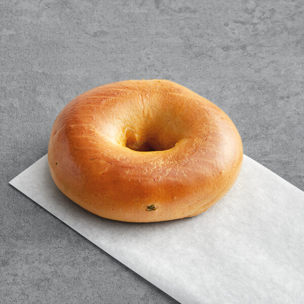 A Just Bagels jalapeno bagel on a white paper.