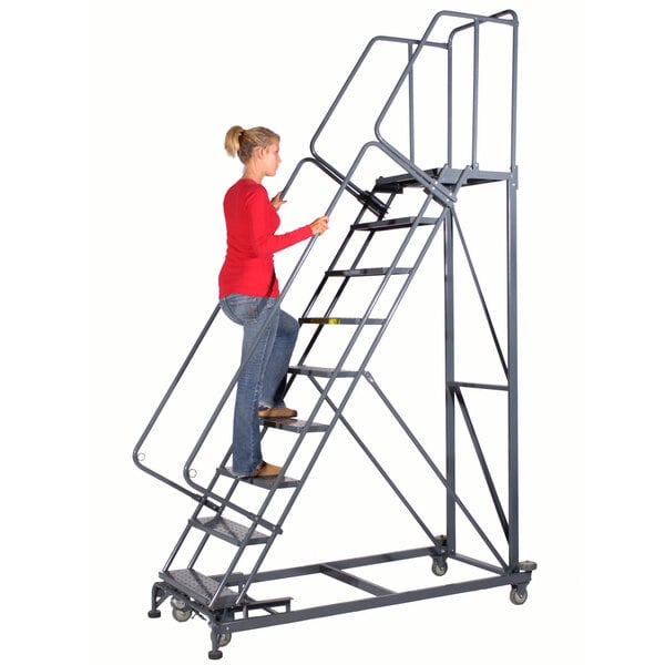 A woman climbing a Ballymore steel safety ladder with a handrail.