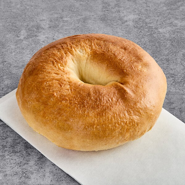 A Just Bagels plain bagel on a white plate.