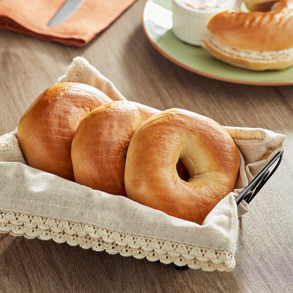 A basket of Just Bagels frozen plain bagels on a table.