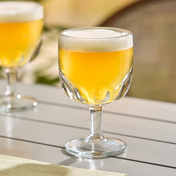 Two Libbey Hoffman House Schooner glasses of beer on a table.