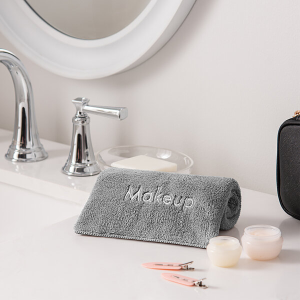 A Monarch Brands coral fleece makeup wash cloth on a counter.