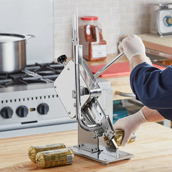 An Avantco manual sausage clipping machine being used to close a bag of sausage links.