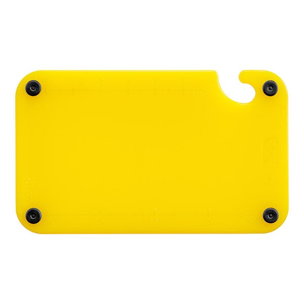 A yellow plastic Choice cutting board with black grips and rulers.