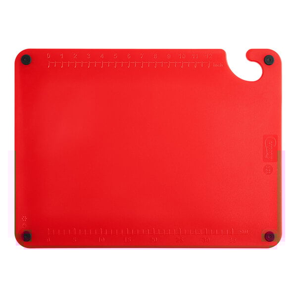 A red plastic Choice cutting board with a handle and rulers.