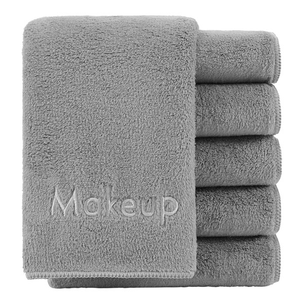 A stack of Monarch Brands gray makeup wash cloths with text on them.