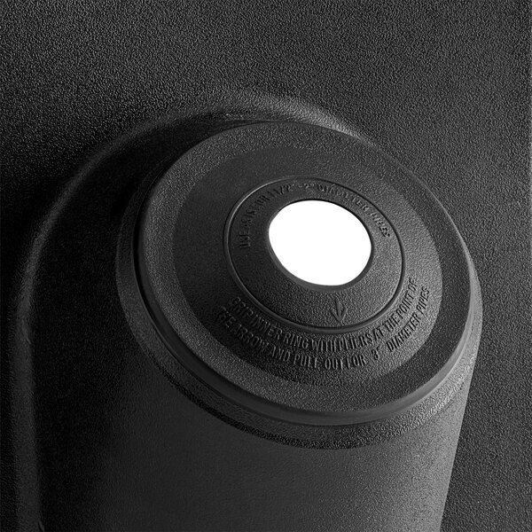 A close up of a black Oatey High-Rise All-Flash No-Calk Roof Flashing with a white circle on the top.