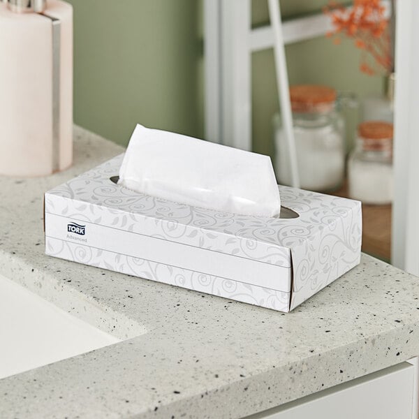 A white box of Tork Advanced facial tissues on a counter.