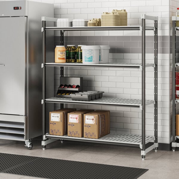 A Cambro metal Camshelving unit in a school kitchen with food containers and boxes on shelves.