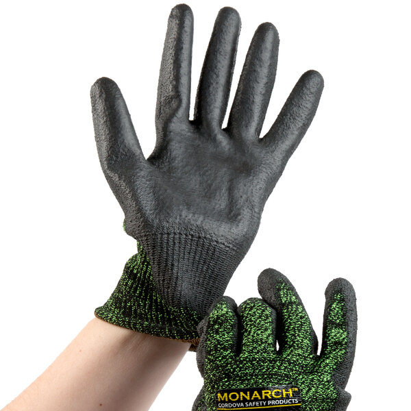 A person wearing small Cordova Monarch cut-resistant gloves with a green and black palm.
