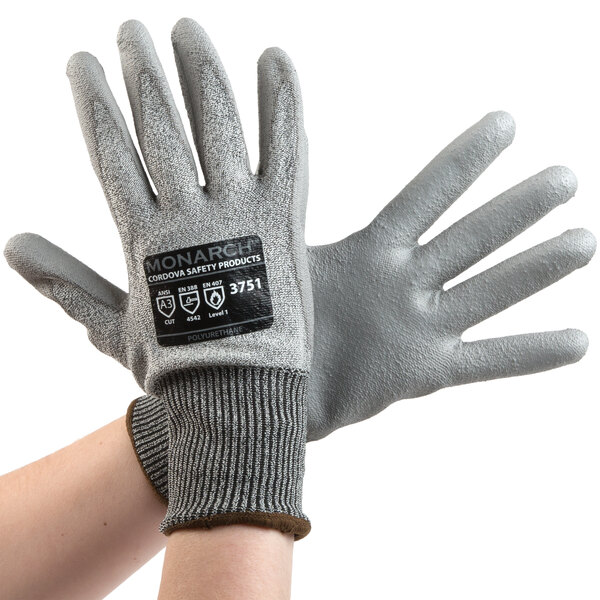 A pair of Cordova Monarch gray gloves with gray polyurethane palm coating and a black label with white text.