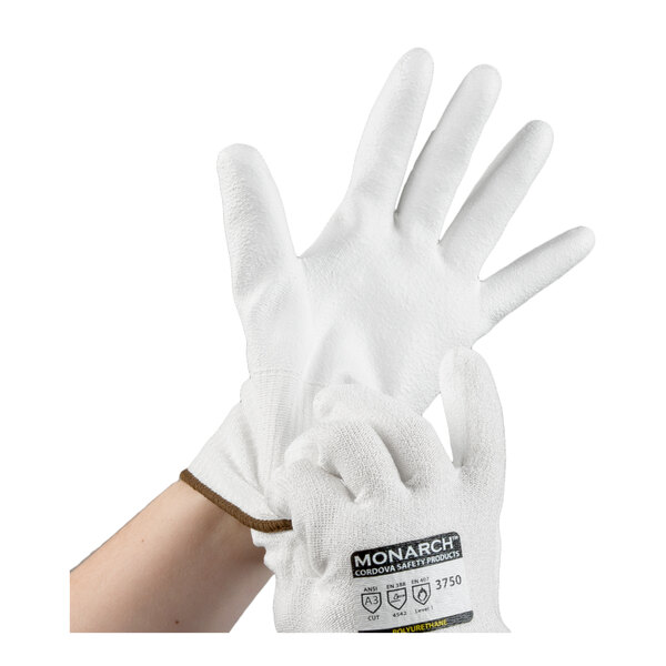 A pair of white cut-resistant gloves with a polyurethane palm coating, labeled as Cordova Monarch, being worn on a person's hands.