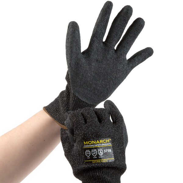 A pair of small black and gray Cordova Monarch cut-resistant gloves with black latex palm coating on a hand.