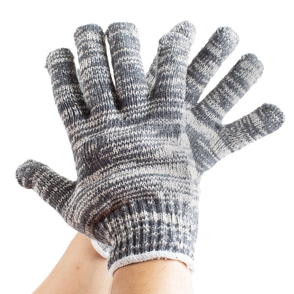 A person's hand wearing a small Cordova work glove with grey and white stripes.