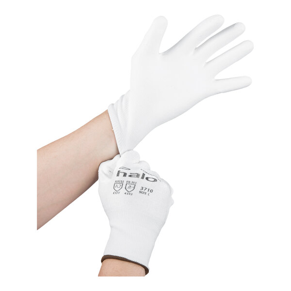 A pair of white HPPE and synthetic fiber gloves with a white polyurethane palm coating, shown being worn on hands.
