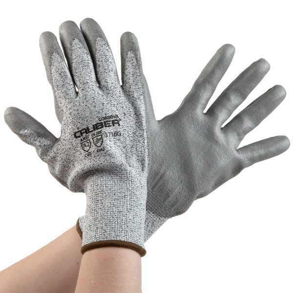 A pair of Cordova Caliber HPPE gloves with gray Polyurethane palms on a white background.