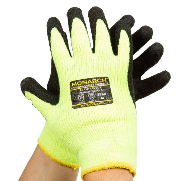 A pair of Cordova Monarch Sub-Zero Hi-Vis green and yellow gloves with black foam latex palms and a label.