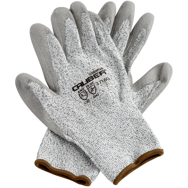A pair of Cordova Caliber gray gloves with gray and white trim on a white background.
