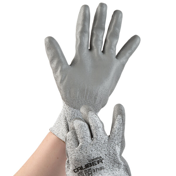 A pair of extra small Cordova grey gloves with silver and grey material and a grey palm coating.