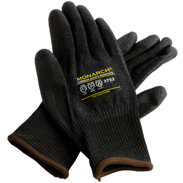 A pair of black Cordova Monarch heavy duty work gloves with black polyurethane palms and yellow logo.