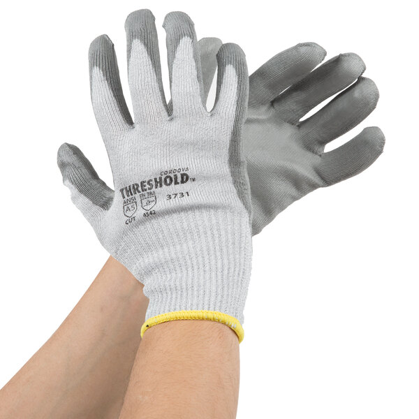 A pair of Cordova cut-resistant gloves with gray palm coating and yellow trim.