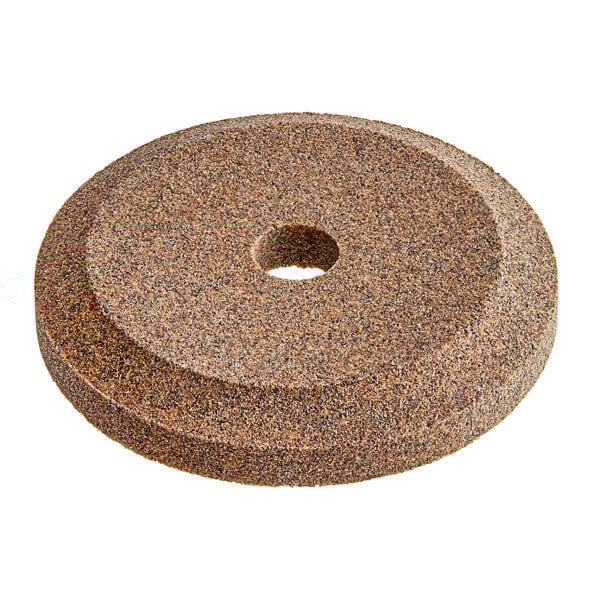 A circular brown stone with a hole in the middle.