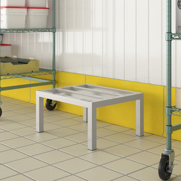 A white table with a Regency aluminum dunnage rack on the side.