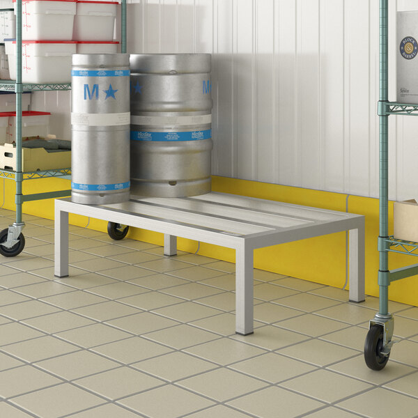 A Regency aluminum dunnage rack with beer kegs on it.