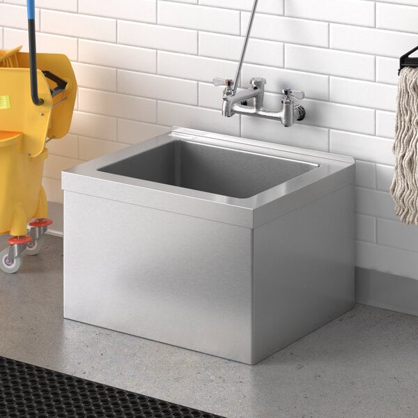 A Steelton stainless steel mop sink with a bucket and mop in the sink.