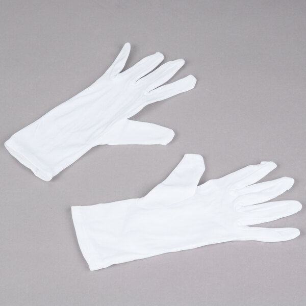A pair of Cordova white inspector's gloves on a gray surface.