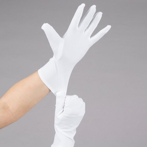 A person's hand wearing white Cordova Inspector's Gloves.