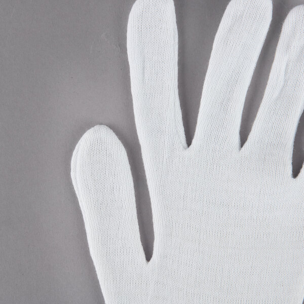 A Cordova white lisle glove on a gray surface.
