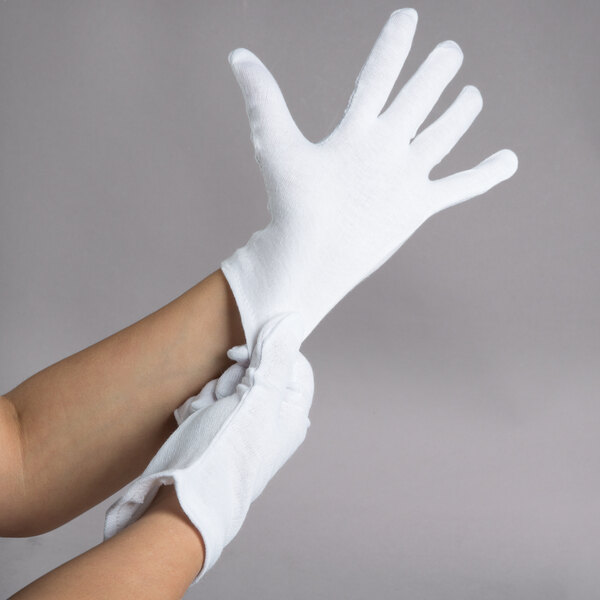 A pair of hands wearing white Cordova inspection gloves.