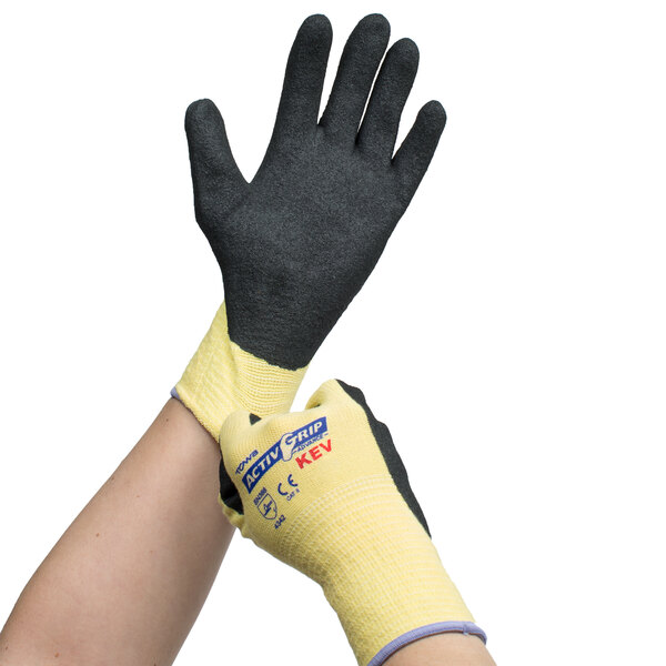 A person wearing Cordova ActivGrip Advance Kevlar gloves with black and yellow coating.