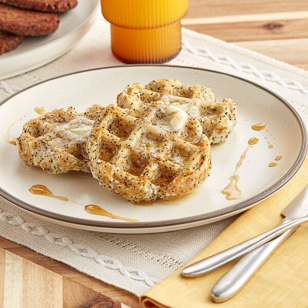 A plate with two Swapples Vegan Everything Waffles and a glass of orange juice.