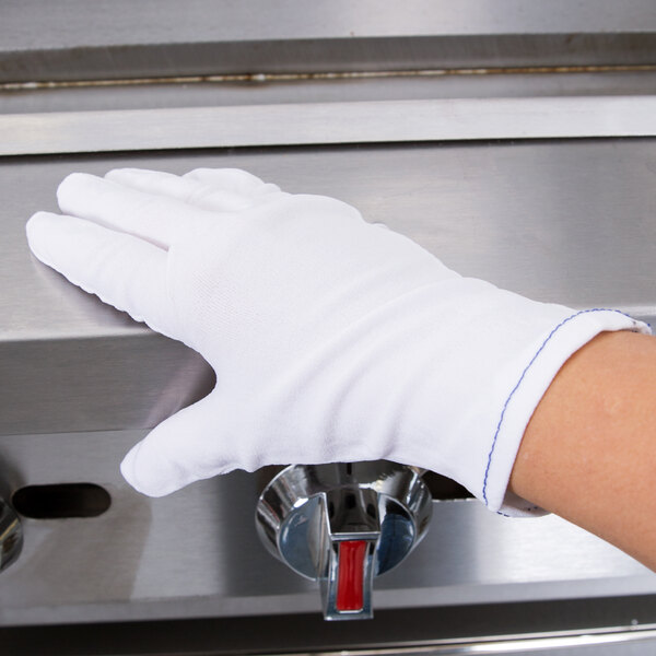 A hand wearing a white Cordova inspector's glove.