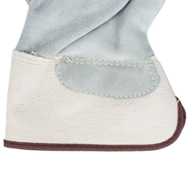 A close up of a pair of white canvas work gloves with brown leather palm coating.