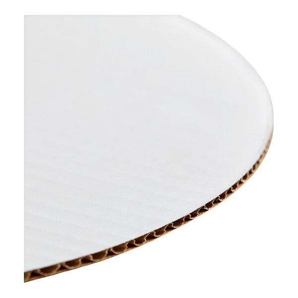 A round, white corrugated cardboard cake circle.