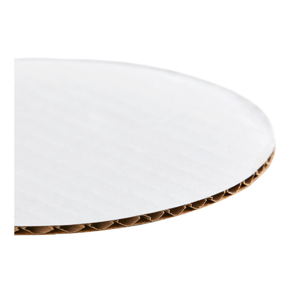 A round, white, corrugated cardboard cake circle.