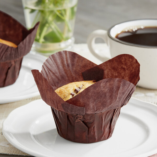 Two Baker's Mark chocolate brown muffins on a plate.