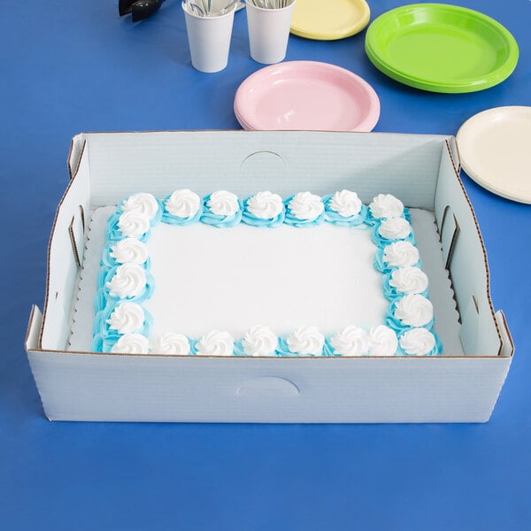 A white sheet cake in a Baker's Mark white corrugated tray in a box.