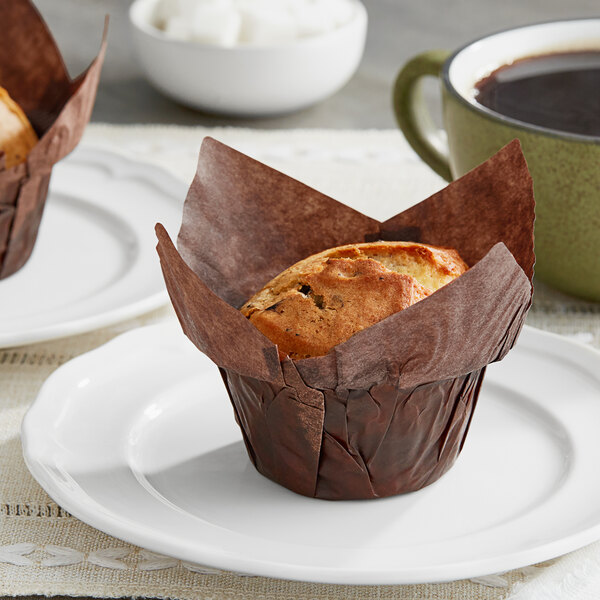 Two Baker's Mark chocolate brown medium high crown muffins on a plate.