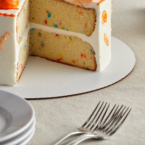 A slice of cake with sprinkles on a Baker's Mark white cake circle.