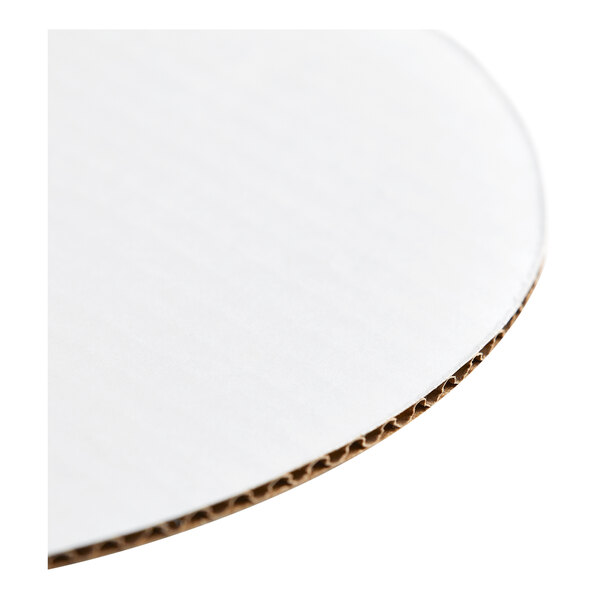 A round, white corrugated cardboard cake circle.