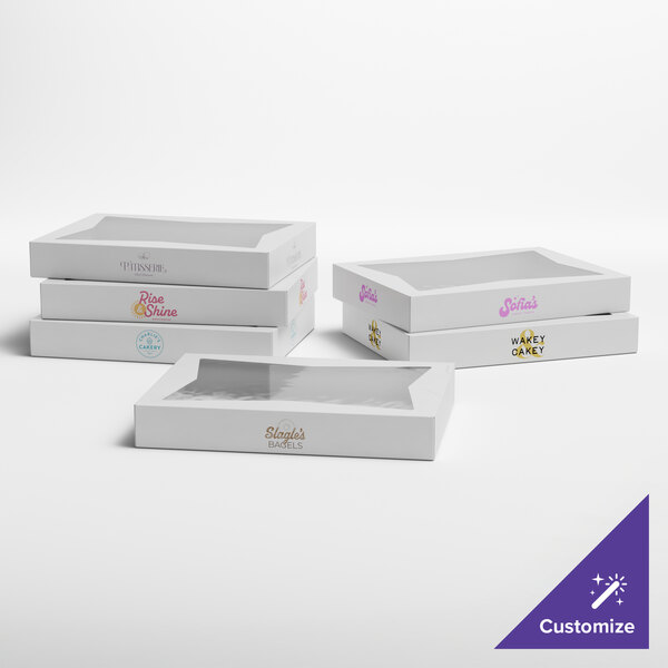 A set of white customizable bakery boxes with clear window tops, designed for packaging donuts or baked goods.