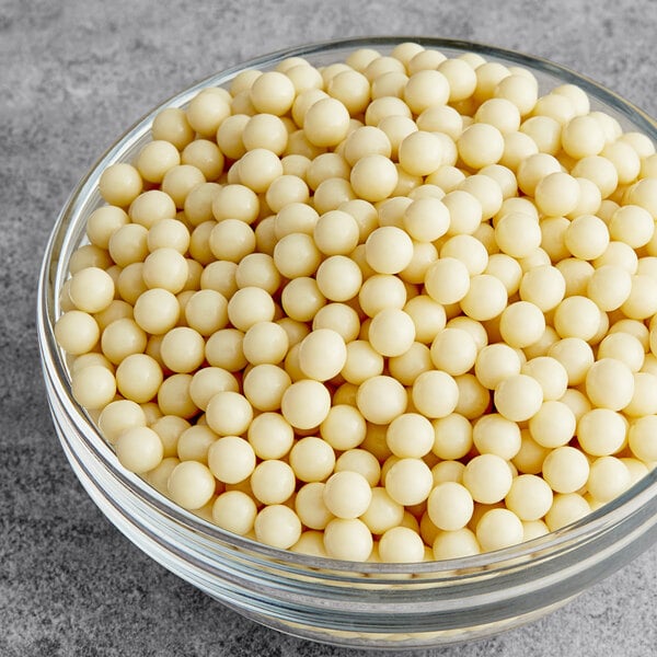 A bowl of Valrhona Opalys white chocolate crunchy pearls.