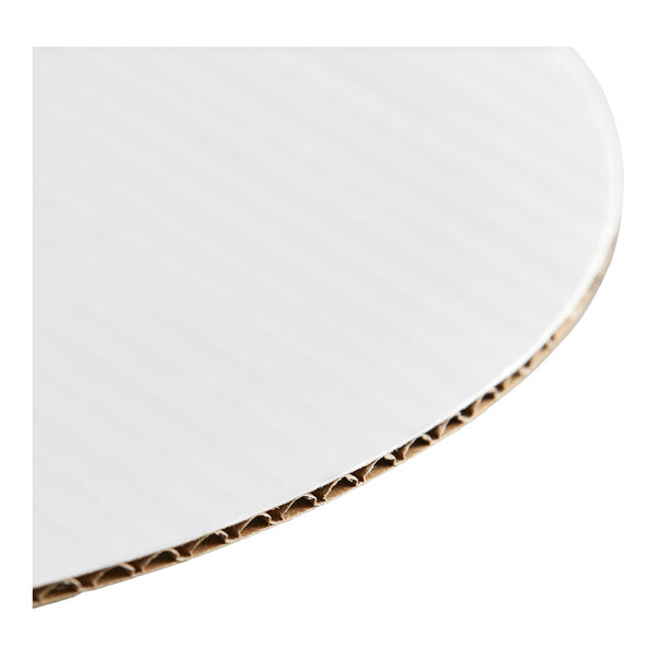 A round, white corrugated cardboard cake circle.